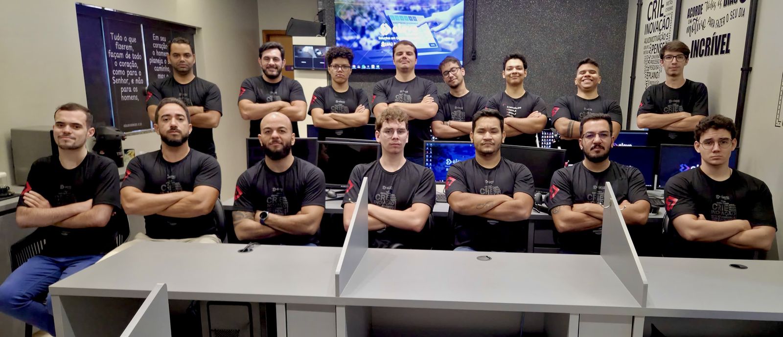 Equipe da Eleve Tecnologia reunida na sede, de braços cruzados